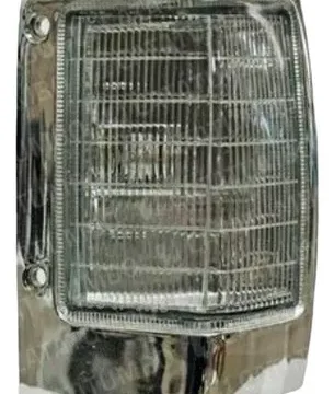Faro delantero de un camión Nissan D21/720 con borde cromado, pieza clave para su iluminación y estética exterior.
